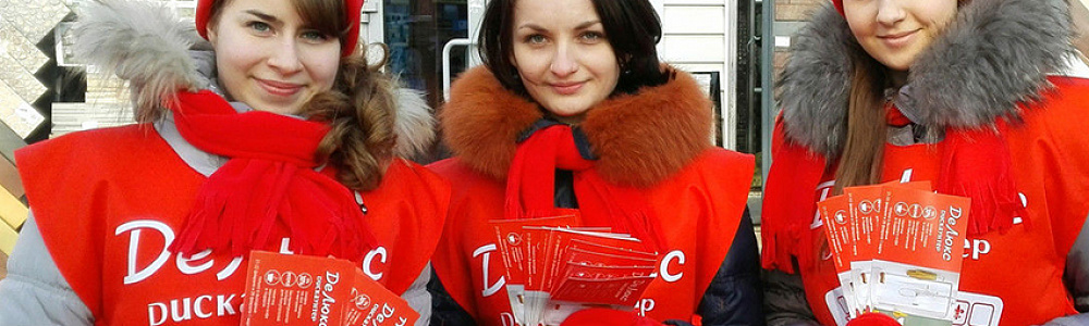 Девушки промоутеры в накидках с логотипом зимой